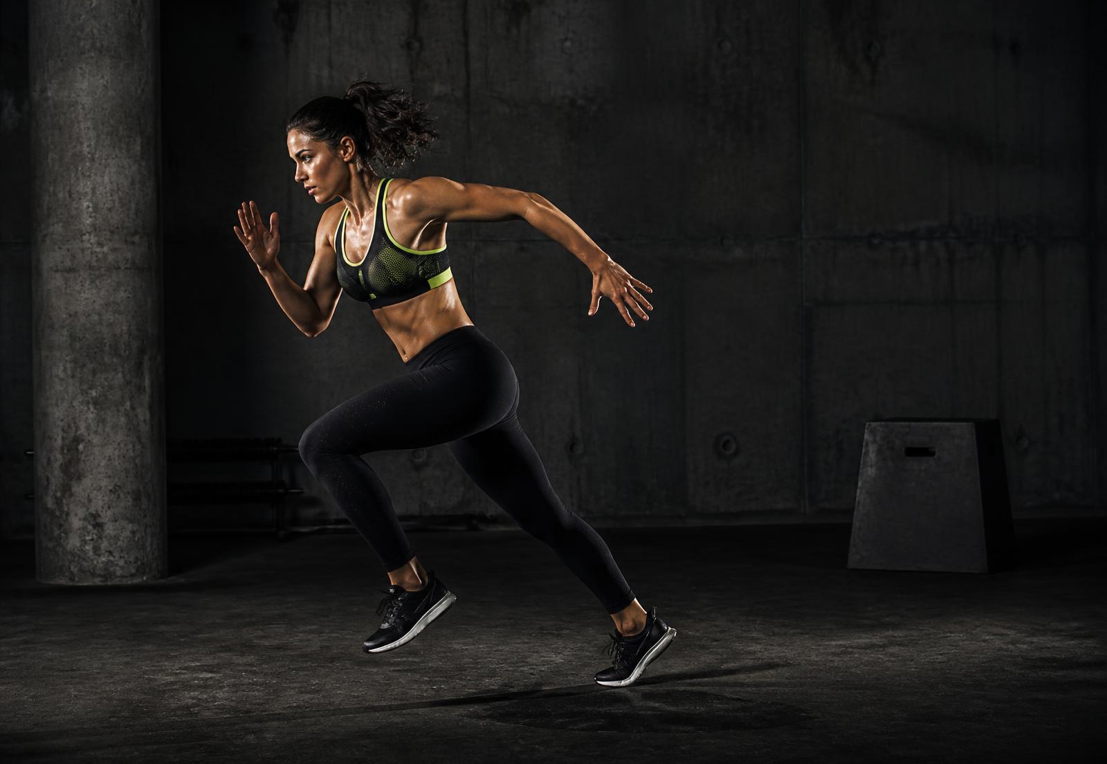 Athlete sprinting in Ivette Enterprises performance leggings and sports bra